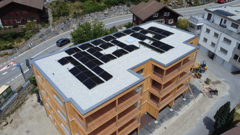 Luftaufnahme eines Wohngebäudes mit PV-Anlage auf dem Flachdach