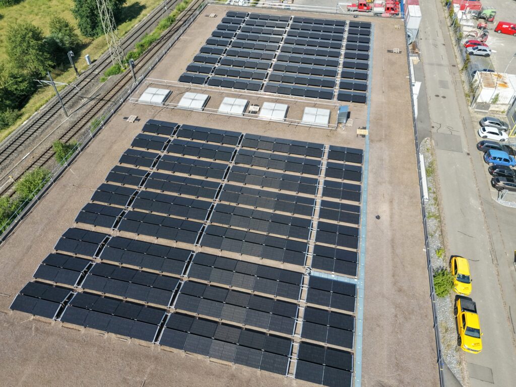Luftaufnahme einer Duraklick PV-Anlage auf dem Flachdach eines Gewerbebaus