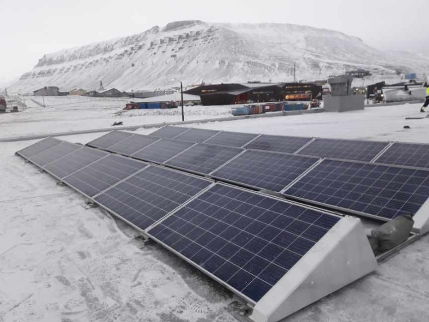 PV-Module in Süd-Aufständerung mit Duraklick auf einem verschneiten Flachdach